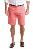 A pair of men's coral-colored stretch twill  shorts with a pattern of shark fins and cocktails, displayed on a model.